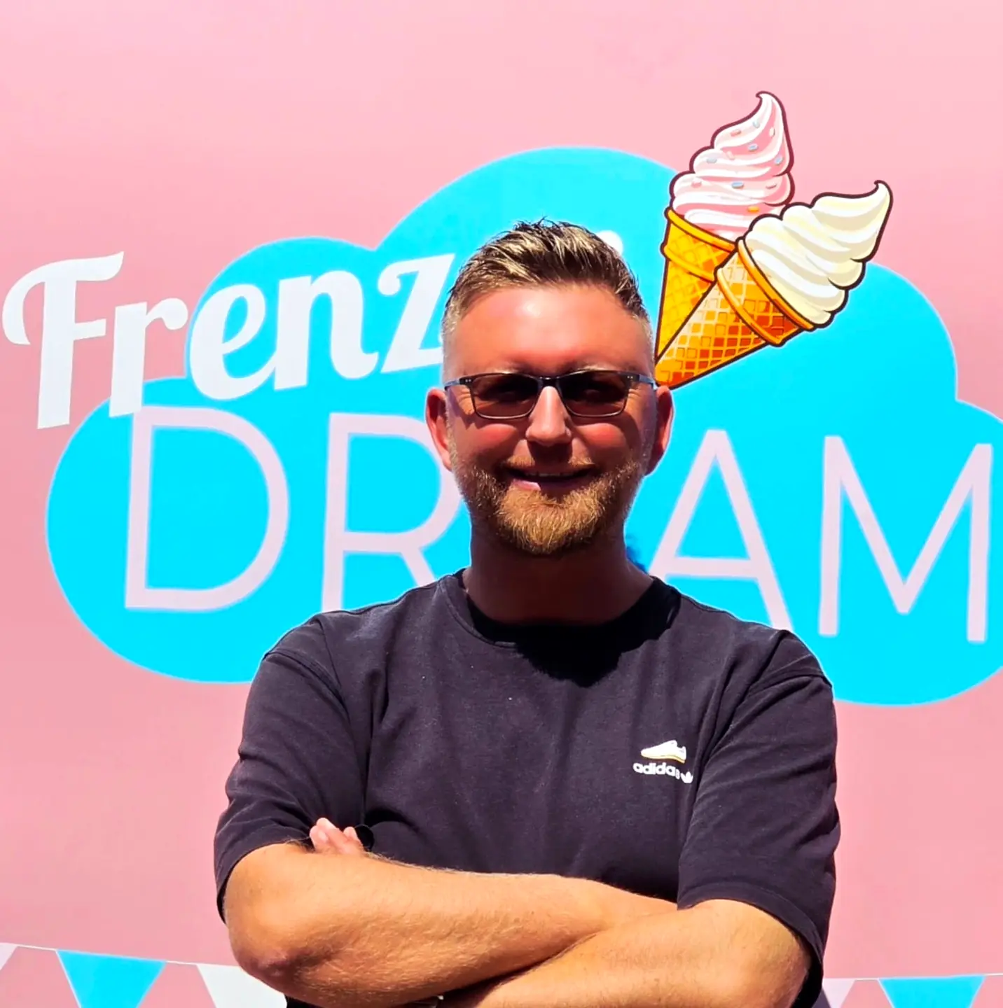 Sascha Frenz lächelt vor einer farbenfrohen Eiswand.